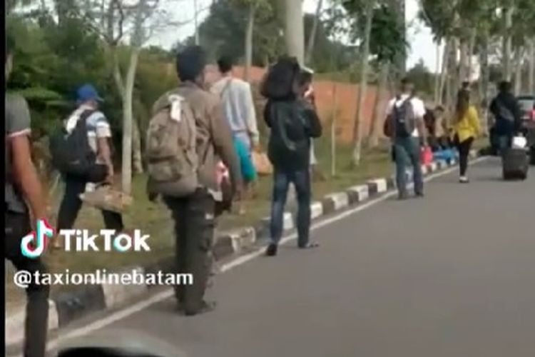 Penumpang pesawat yang baru tiba di Bandara Hang Nadim, Batam, Kepulauan Riau, berjalan kaki hingga 2 kilometer untuk menuju titik penjemputan taksi online.