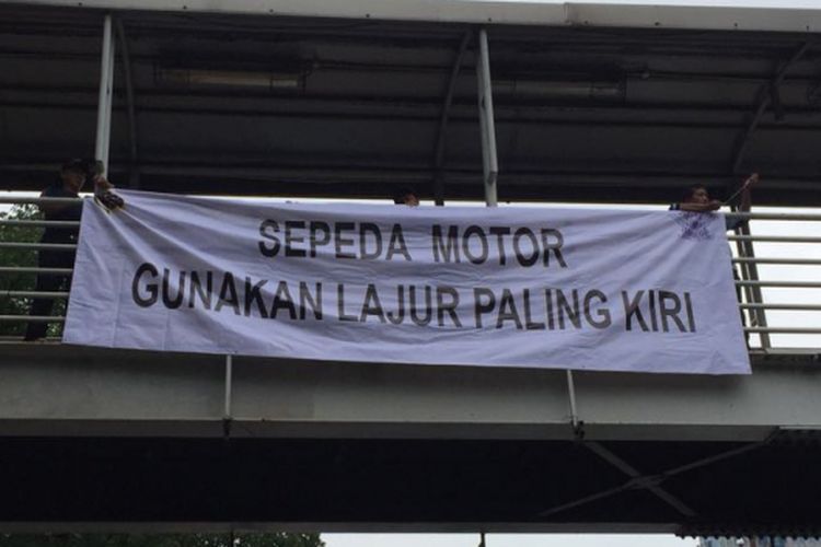 Spanduk imbauan untuk sepeda motor agar menggunakan lajur paling kiri dipasang di kawasan Jalan MH Thamrin, Kamis (18/1/2018).