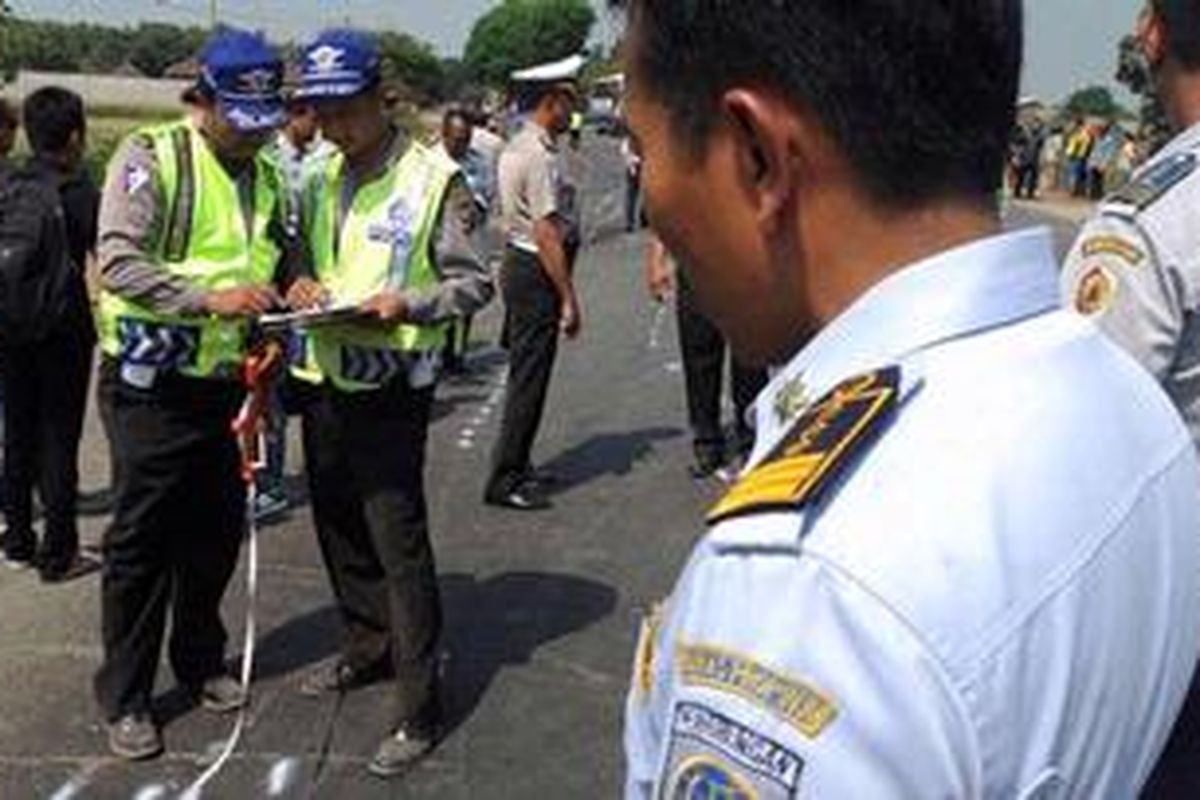 Petugas melakukan olah tempat kejadian perkara (TKP) pada kecelakaan antara PO Sumber Kencono tujuan Surabaya-Jombang dengan minibus di Jalan Raya Bypass Puri Indah, Desa Balungmojo, Kecamatan Puri, Kabupaten Mojokerto, Jawa Timur, Senin (12/9/2011). Kecelakaan menyebabkan 19 orang tewas.