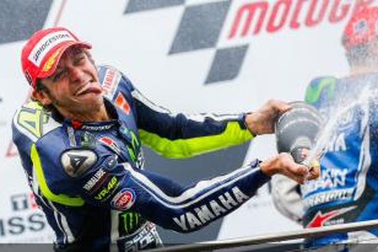 Pebalap Movistar Yamaha asal Italia, Valentino Rossi, merayakan kemenangan pada GP Australia di atas podium Sirkuit Phillip Island, Minggu (19/10/2014).
