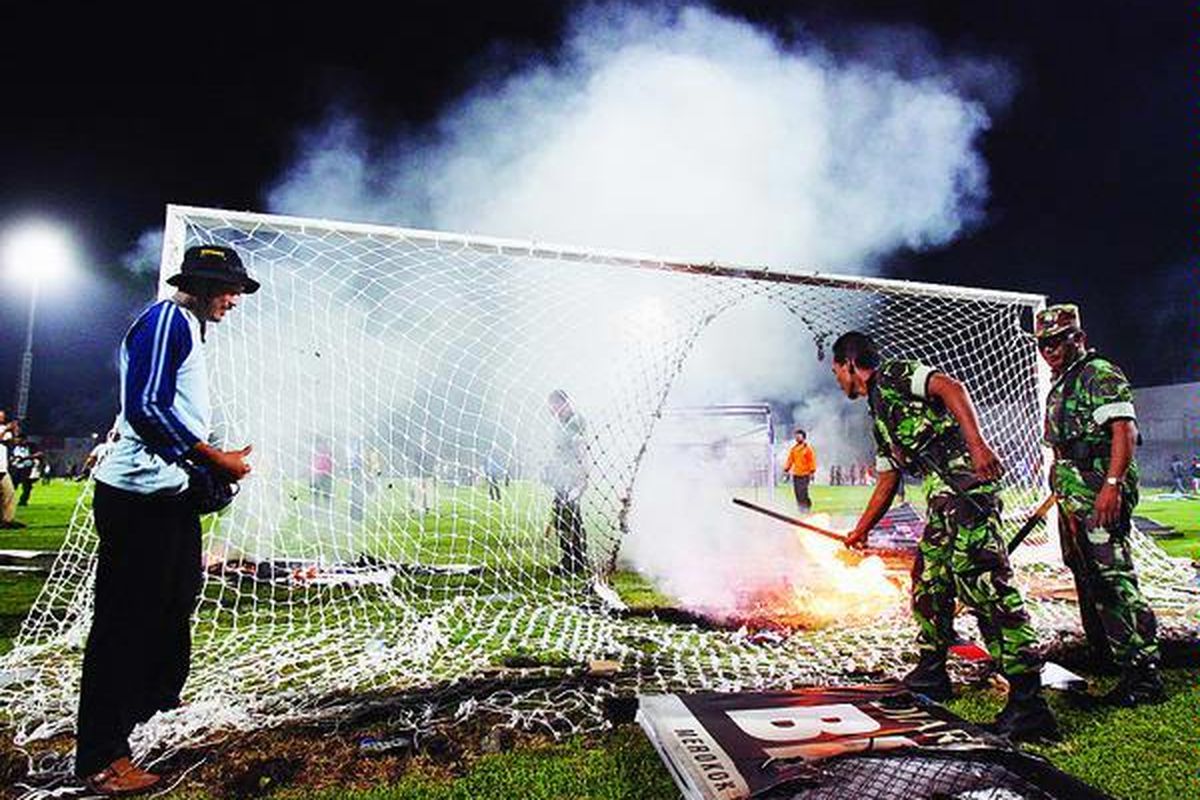 Petugas keamanan memadamkan api yang membakar papan sponsor dan jala gawang pada pertandingan Liga Djarum Super 2007 antara Persiwa Wamena dan Arema Malang di Kediri. Ini salah satu kerusuhan terburuk akibat pengelolaan kompetisi yang amburadul, yang jelas merugikan sponsor.
