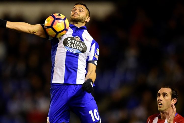 Penyerang Deportivo La Coruna,  Florin Andone (kiri), berusaha mengontrol bola dalam kawalan bek Atletico Madrid, Diego Godin, saat kedua tim bertemu pada pertandingan La Liga di Stadion Municipal de Riazor, pada 2 Maret 2017. 