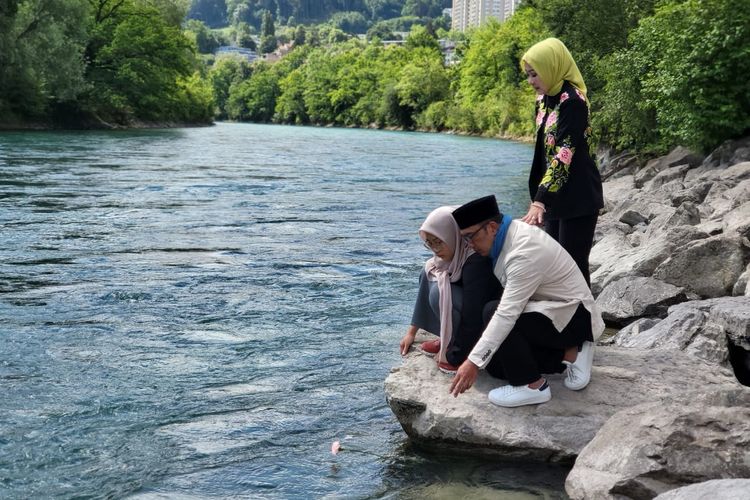 Gubernur Jawa Barat Ridwan Kamil beserta istri dan anak perempuannya menghanyutkan bunga mawar merah muda di Sungai Aaree, Bern, Swiss. 