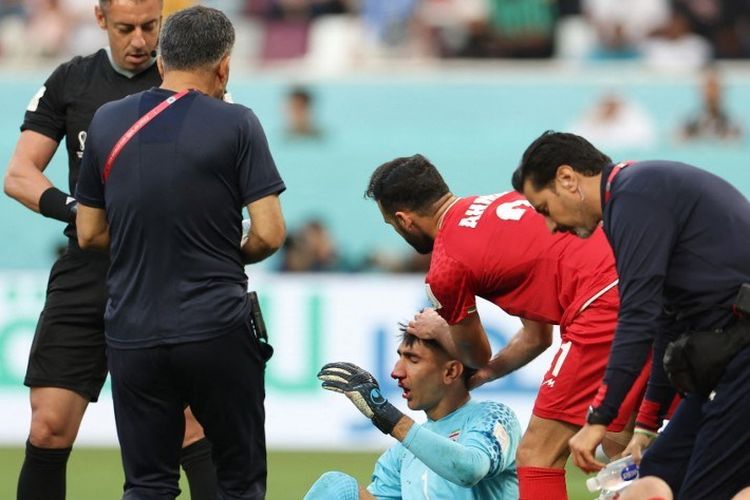 Kiper Iran Alireza Beiranvand (kiri) bereaksi karena cedera setelah benturan kepala dengan bek Iran Majid Hosseini (bawah) pada pertandingan Grup B Piala Dunia 2022 Qatar antara Inggris vs Iran di Stadion Internasional Khalifa di Doha pada Senin 21 November 2022.