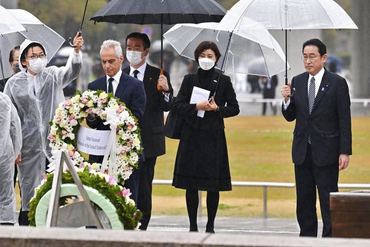 Duta Besar AS untuk Jepang Rahm Emanuel, kiri tengah, bersama Perdana Menteri Jepang Fumio Kishida, paling kanan, meletakkan karangan bunga di tugu peringatan para korban bom atom di Taman Peringatan Perdamaian Hiroshima di Hiroshima, Jepang, Sabtu, 26 Maret 2022.
