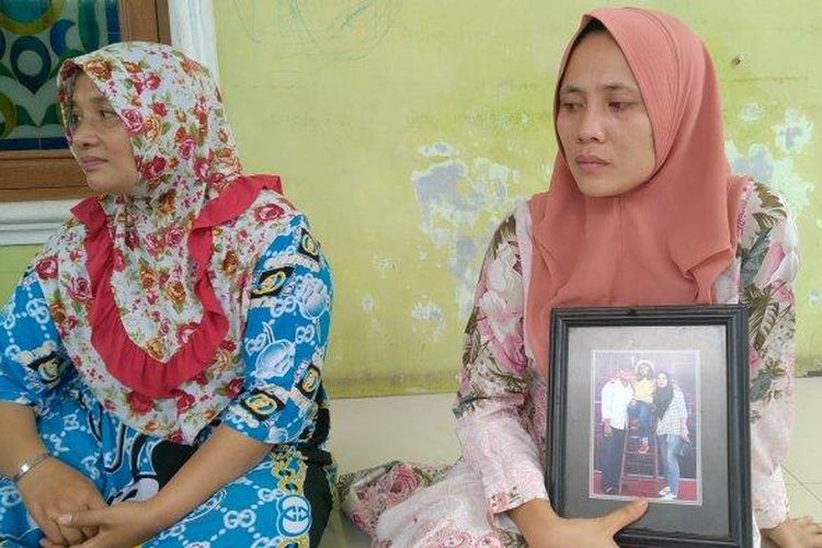 Yulia, istri almarhum Ridho yang menjadi korban penembakan misterius, memegang foto keluarganya saat ditemui di rumah duka, Jalan Yos Sudarso KM 14,5 Simpang Darmin Gang Keluarga, Medan Martubung, Kota Medan, Senin (29/3/2021). 
