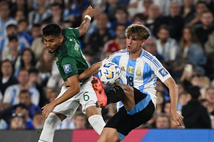 Gelandang Bolivia Adalid Terrazas dan gelandang Argentina Nico Paz bertarung memperebutkan bola pada laga Kualifikasi Piala Dunia FIFA 2026 zona Amerika Selatan antara Argentina dan Bolivia di stadion Mas Monumental, Buenos Aires, 15 Oktober 2024. (Foto oleh Luis ROBAYO / AFP)