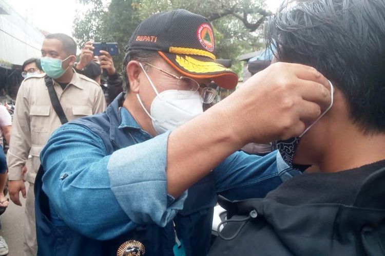 Plt Bupati Cianjur Herman Suherman saat memakaikan masker kepada seorang warga yang kedapatan abai terhadap protokol kesehatan Covid-19 itu di kawasan Pasar Muka Cianjur, Kamis (14/01/2021).