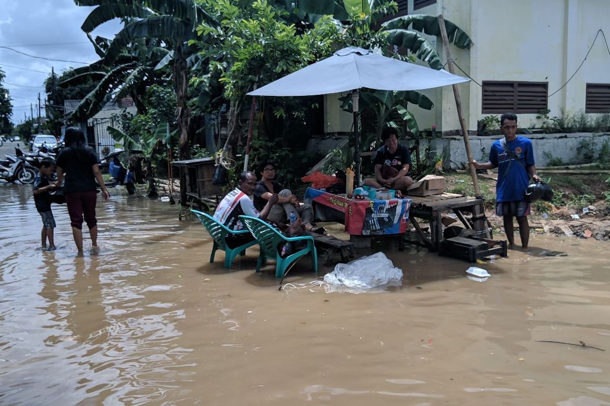 Warga Kelurahan Gebang Raya Kecamatan Periuk Tangerang bersantai di tengah banjir, Rabu (26/2/2020)