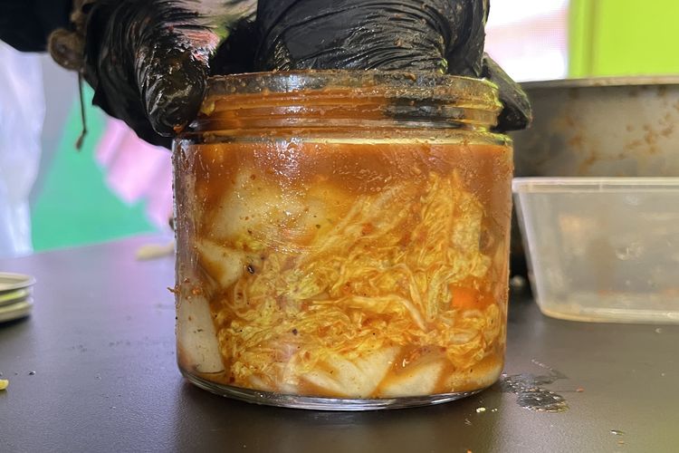 Proses memasukkan kimchi ke dalam stoples dengan cara dipadatkan.