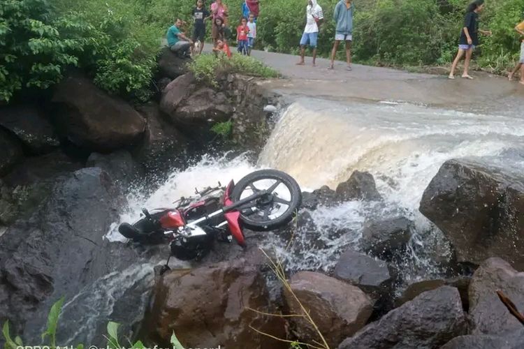 Foto : Kendaraan Vixion milik korban tergeletak di atas batu di sungai tempat korban terseret.