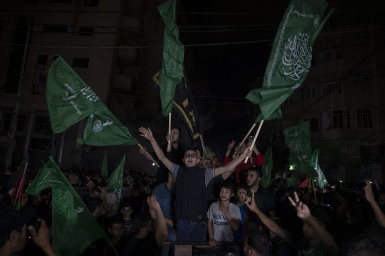 Warga Palestina pada Jumat (21/5/2021) mengibarkan bendera hijau Hamas sambil meneriakkan yel-yel merayakan gencatan senjata antara Israel dengan Hamas, setelah 11 hari konflik di Gaza.