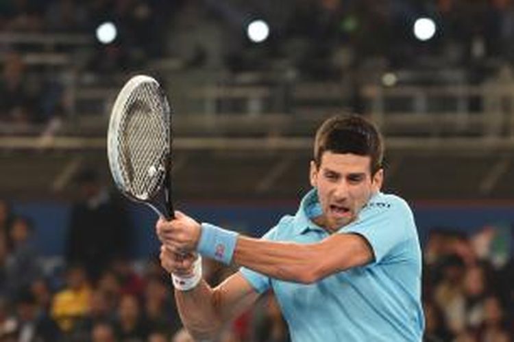 Petenis Serbia, Novak Djokovic, mengembalikan bola ke arah petenis Swiss, Roger Federer, pada pertandingan lanjutan International Premier Tennis League (IPTL) di New Delhi, India, Senin (8/12/2014).
