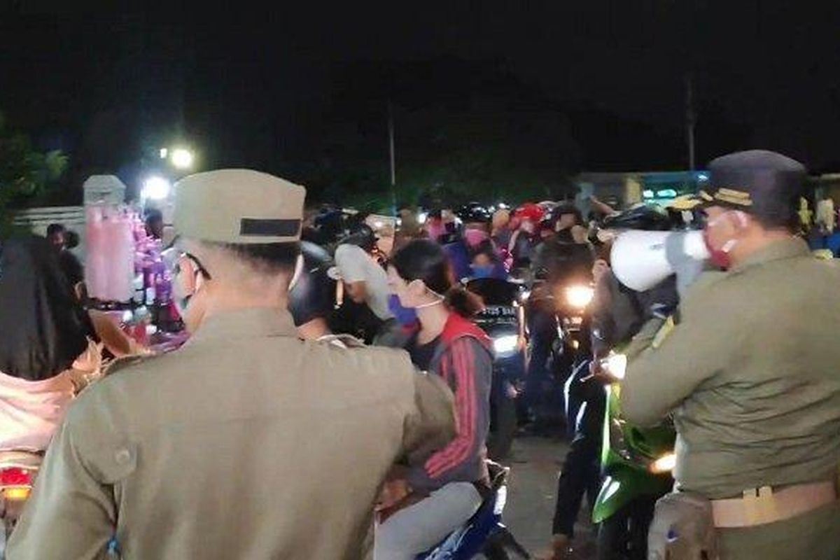 Personel Satpol PP Jakarta Timur saat membubarkan kerumunan PKL dan warga di KBT, Duren Sawit, Kamis (22/5/2020) 

