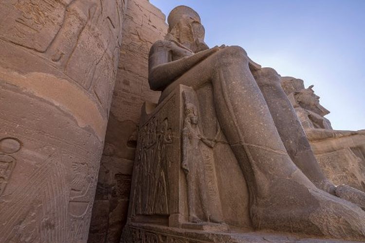 Sebuah gambar memperlihatkan ukiran kecil Ratu Nefertari di belakang kaki suaminya yang kolosal Ramses II di Kuil Luxor, di luar kota selatan Mesir dengan nama yang sama pada 27 Juli 2022. 