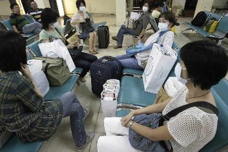 Penumpang pesawat mengenakan masker saat berada di ruang tunggu penumpang transit rute domestik di Bandara Internasional Ngurah Rai, Denpasar, Bali, Sabtu (2/5/2009). Upaya pencegahan penularan flu babi (swine flu), misalnya mengenakan masker di tempat umum yang memungkinkan pertemuan orang dari luar negeri, seperti bandara, penting diperhatikan. Pemerintah Indonesia mengeluarkan travel warning bagi warga Meksiko ke Indonesia. 