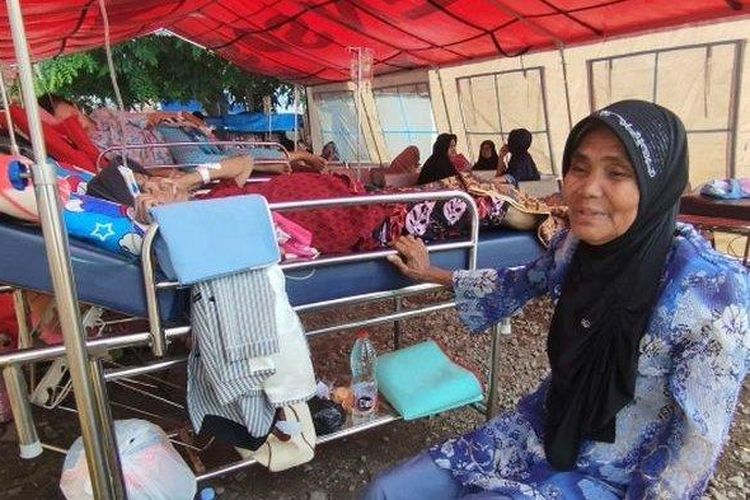 Otih (62) sedang menunggui anaknya, Nia Kurniasih (40), yang terbaring sakit di tenda darurat RS Pakuwon, Sumedang, Senin (1/1/2024). Akibat gempa Sumedang, Nia dan sejumlah pasien lain dirawat di tenda darurat.