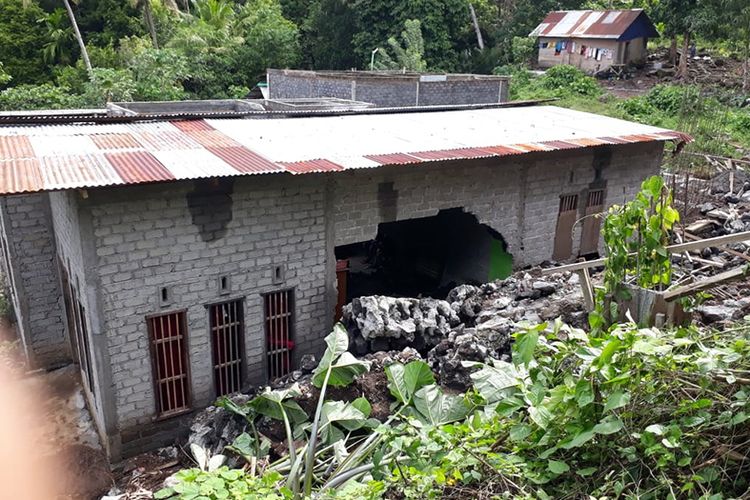 Sebuah dinding rumah roboh setelah tertimpa reruntuhan tanggul yang jebol karena longsor, Jumat (6/7/2018).