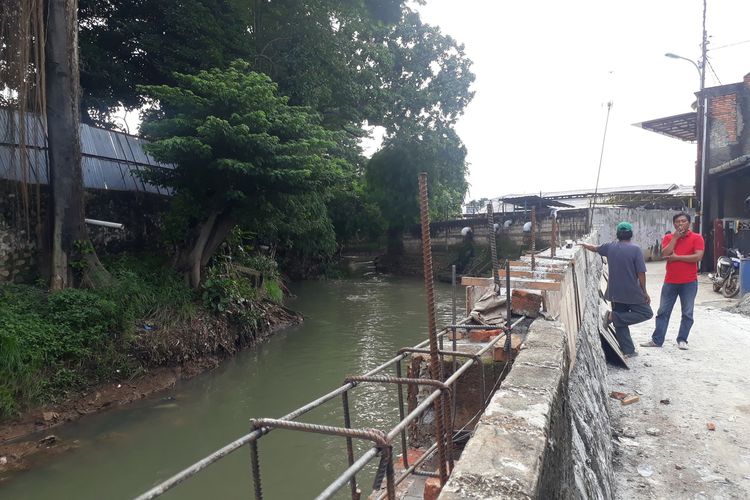 Tanggul Kali Cipinang yang jebol di wilayah RW 011, Kelurahan Kramat Jati, Kecamatan Kramat Jati, Jakarta Timur, dalam tahap perbaikan, Rabu (22/1/2020).