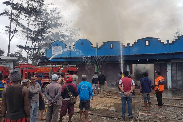 Pemadam kebakaran saat memadamkan api yang membakar kios di Jalan Trans Jayapura - Wamena, Selasa (25/12/2018)