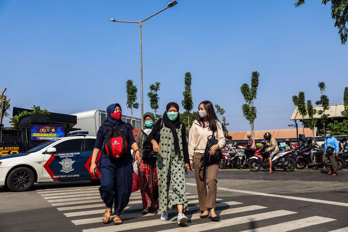 Pekerja menggunakan masker saat berjalan menuju perkantoran di Kawasan Tanah Abang, Jakarta Pusat, Senin (21/9/2020). PSBB kembali diterapkan mulai tanggal 14 September 2020, berbagai aktivitas kembali dibatasi yakni aktivitas perkantoran, usaha, transportasi, hingga fasilitas umum.