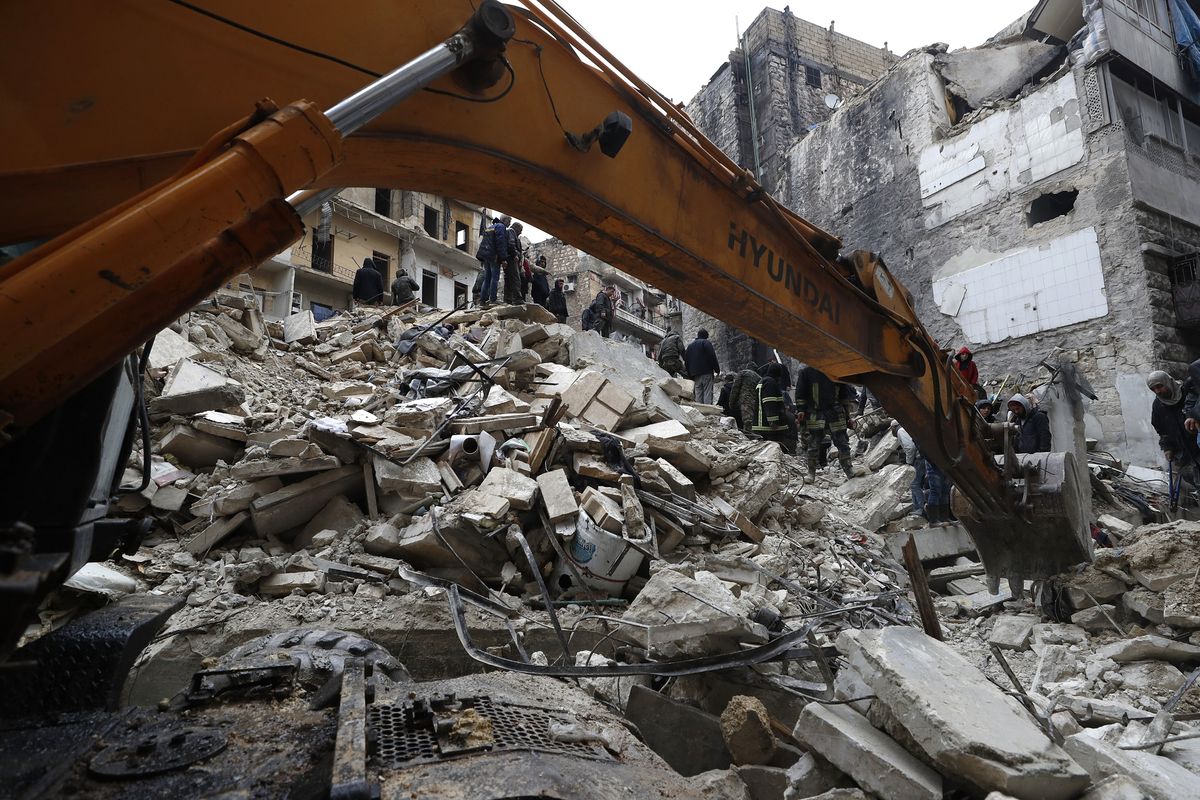 Para pekerja Pertahanan Sipil Suriah dan petugas keamanan menyisir puing-puing bangunan yang ambruk di Aleppo, Suriah, Senin (6/2/2023). Gempa Suriah terjadi bersamaan di Turkiye yang menewaskan lebih dari 5.000 orang.