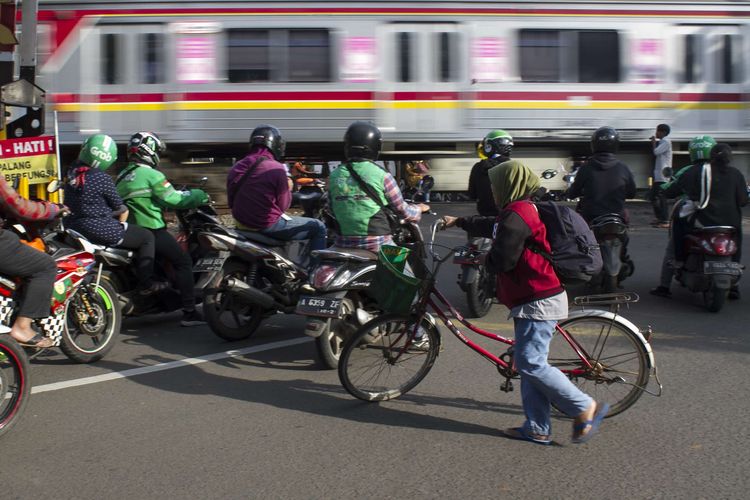 Pengendara melintas di perlintasan kereta api wilayah Bumi Bintaro Permai, Pondok Aren, Jakarta Selatan, Sabtu (22/2/2020). Tidak berfungsinya palang pintu di perlintasan kereta api sejak 2 tahun lalu mengancam keselamatan warga.