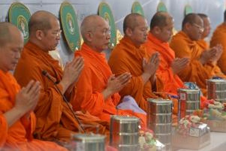 Para biksu Buddha melantunkan doa-doa dalam upacara mengenang korban serangan bom di dekat Kuil Erawan, Bangkok.