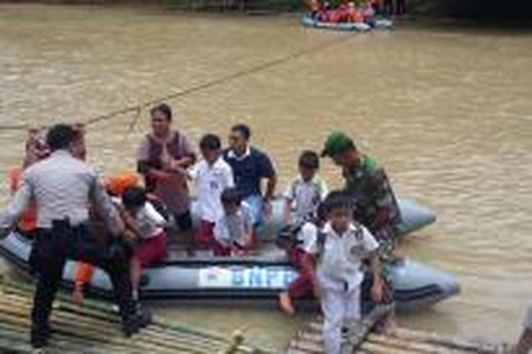 Siswa SD Negeri 1 Pajagan, Kabupaten Lebak, Banten, menaiki perahu karet milik Badan Nasional Penanggulangan Bencana (BNPB), Senin (16/3/2015).