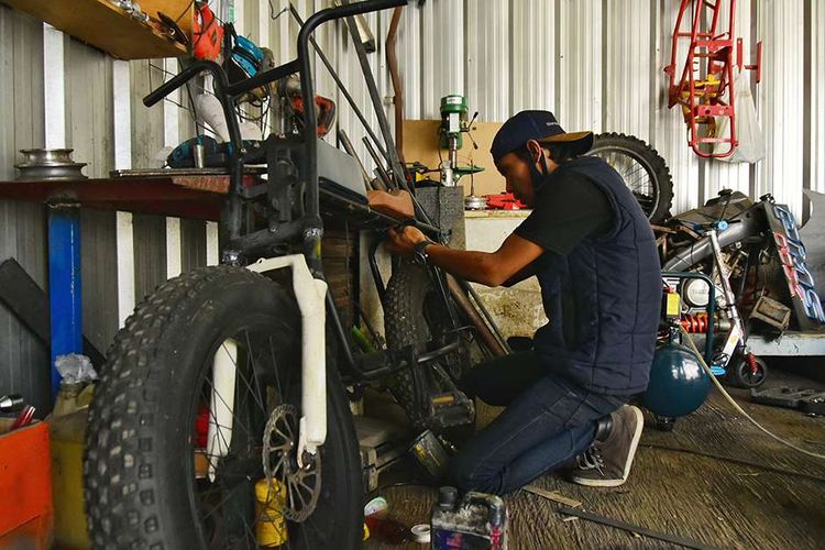 Riksi Julian Rahmat (36) mengerjakan modifikasi sepeda menjadi bertenaga listrik dengan sumber energi baterai dan menggunakan penggerak dinamo, di Bengkel DMR Custom miliknya di kawasan Randusari Utara, Kecamatan Antapani, Bandung, Jawa Barat, Senin (9/8/2021). Riksi dibantu rekannya di bengkel tersebut sudah berhasil merubah sepeda, motor, skuter, bajaj, segway, jetski, papan seluncur, hingga electric unicycle (EUC) menjadi bertenaga listrik atau hybrid.