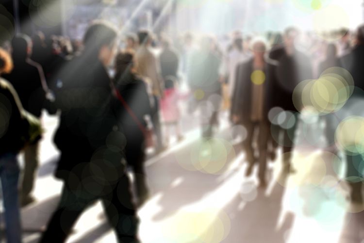 blurry background image of people walking on busy street