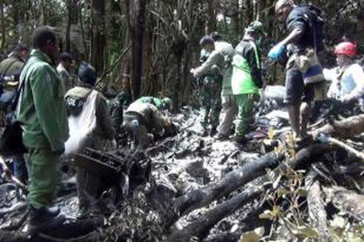 TIm SAR melakukan pencarian korbam di tengah puing pesawat Trigana Air ATR 42-300 twin-turboprop yang jatuh di kawasan pegunungan di Oksibil, Papua, 18 Agustus 2015. Sebanyak 5 awak dan 49 penumpang dilaporkan meninggal.