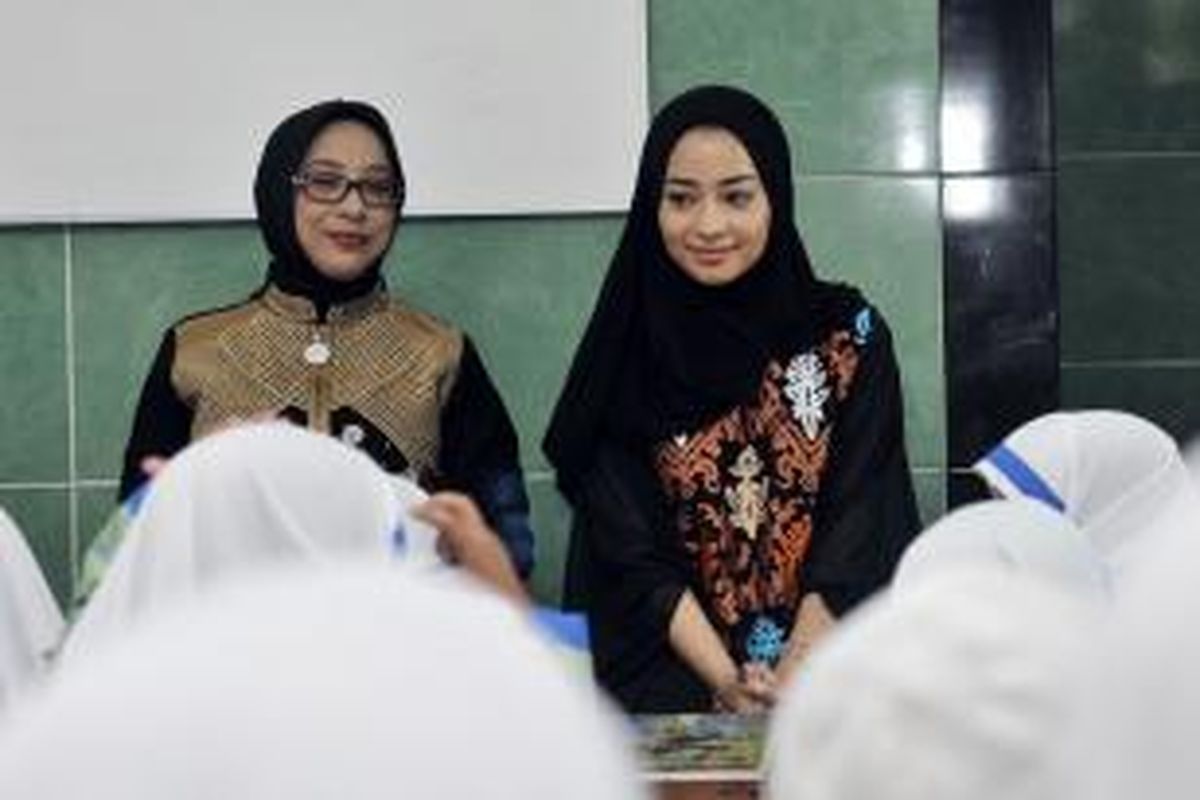 Artis peran Nikita Willy (kanan) mengajar membaca Al Quran di Taman Bacaan Al Quran Nikita Willy, di Mushala Umi Kulsum, Jatiwaringin, Bekasi, Jawa Barat, Selasa (19/8/2014). Taman bacaan tersebut milik Nikita.