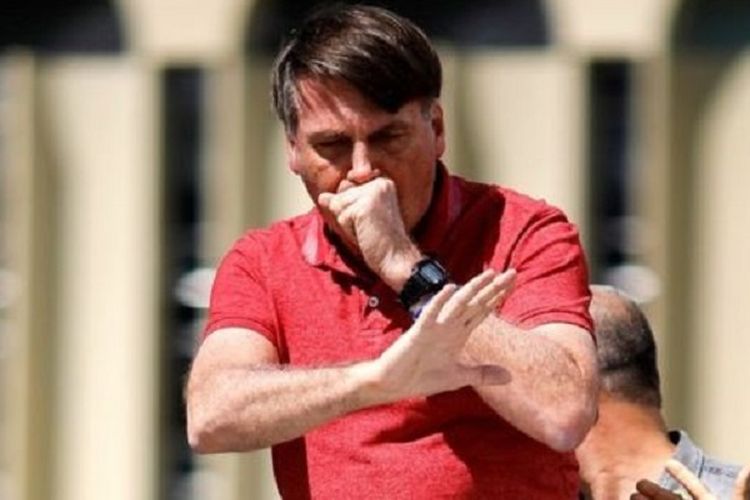 Presiden Brasil Jair Bolsonaro terlihat batuk ketika menghadiri demonstrasi menentang lockdown Covid-19 di Brasilia, 19 April 2020.