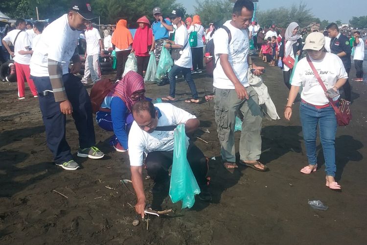 Warga saat memunguti sampah bersama Menteri Lingkungan Hidup  dan Kehutanan di Pantai Sendang Sikucing Rowosari Kendal. 