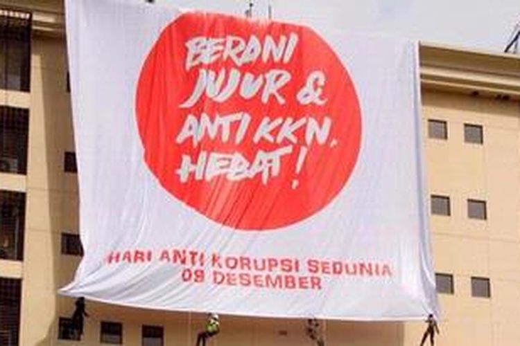 Polisi memasang spanduk anti korupsi raksasa di gedung Trans National Crime Center, Mabes Polri, Jakarta Selatan, Jumat (7/12/2012). Selain untuk memperingati Hari Anti Korupsi Internasional pada 9 Desember, spanduk ini merupakan bentuk komitmen Polri untuk terus bekerjasama dengan KPK dalam memberantas korupsi di Indonesia. 