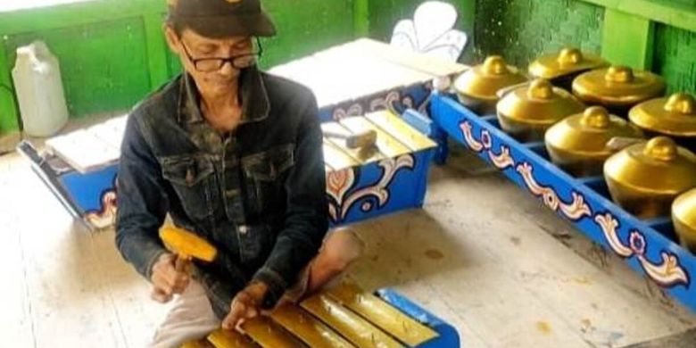 Saman (57), pria paruh di Cianjur, Jawa Barat, sedang mencoba alat tradisonal buatannya sebelum dikirimkan ke pemesan. Keterbatasan fisik tak menyurutkan semangatnya gigih bekerja.