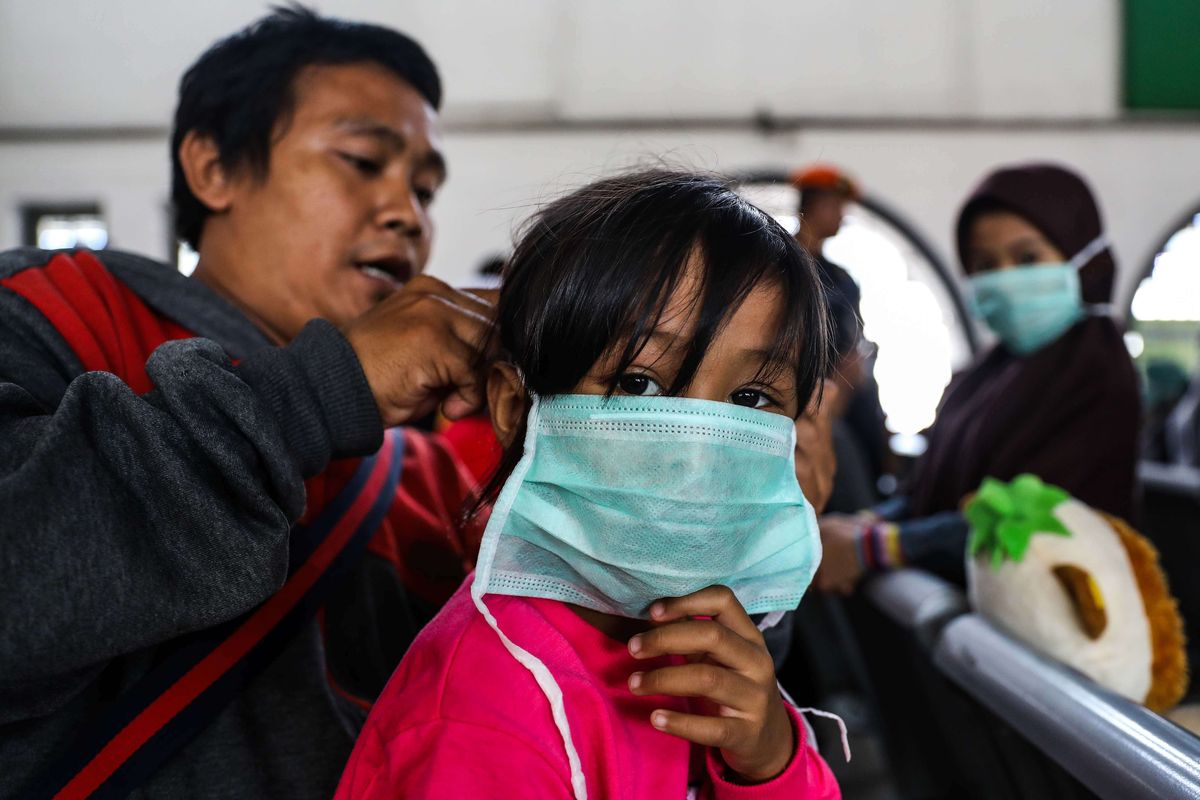 Penumpang menggunakan masker yang dibagikan petugas kesehatan dalam sosialisasi COVID-19 di Stasiun Pasar Senen, Jakarta, Senin (9/3/2020). PT KAI juga menyediakan layanan klinik kesehatan di masing-masing stasiun serta melakukan pengecekan suhu tubuh menggunakan termometer kepada penumpang yang membutuhkan layanan kesehatan.