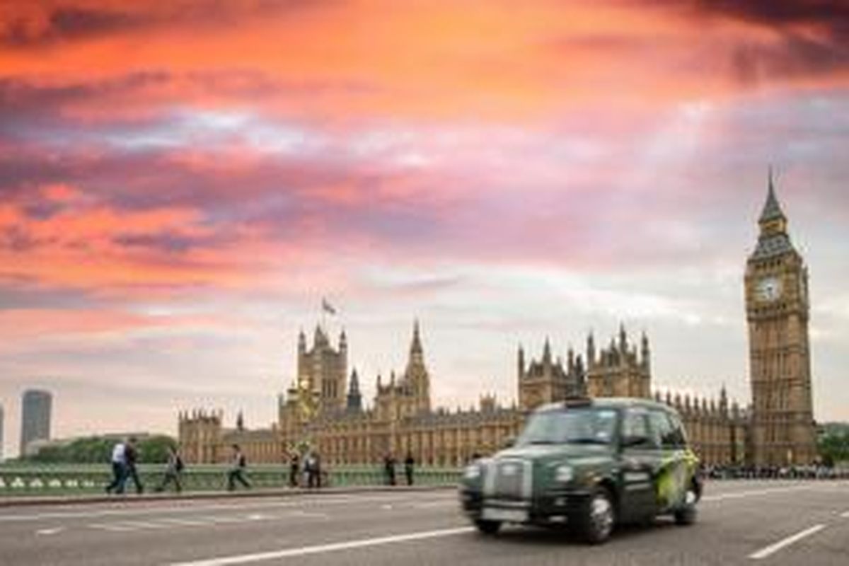 Taksi khas London melintas di depan gedung parlemen Inggris.