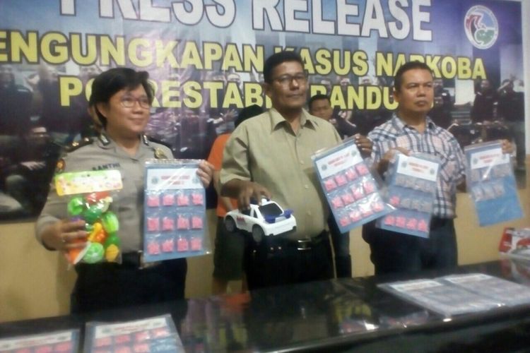 Wakasat Narkoba Polrestabes Bandung Kompol Salim Aziz (tengah) sedang memegang barang bukti narkoba jenis ekstasi dan sebuah mainan mobil-mobilan anak, Jumat (25/5/2018)
