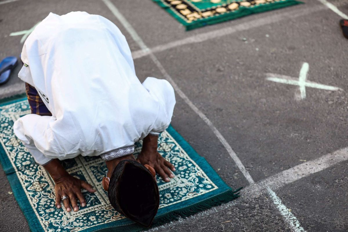 Umat muslim melaksanakan shalat Idul Adha di Jalan Pramuka Raya, Cempaka Putih, Jakarta Timur, Jumat (31/7/2020). Umat muslim menggelar shalat Idul Adha secara berjamaah dengan menerapkan protokol kesehatan seperti jaga jarak serta wajib mengenakan masker guna mencegah penyebaran COVID-19.