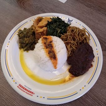 Ilustrasi nasi Padang lengkap dengan lauk dan mi rasa rendang di Restoran Sederhana.