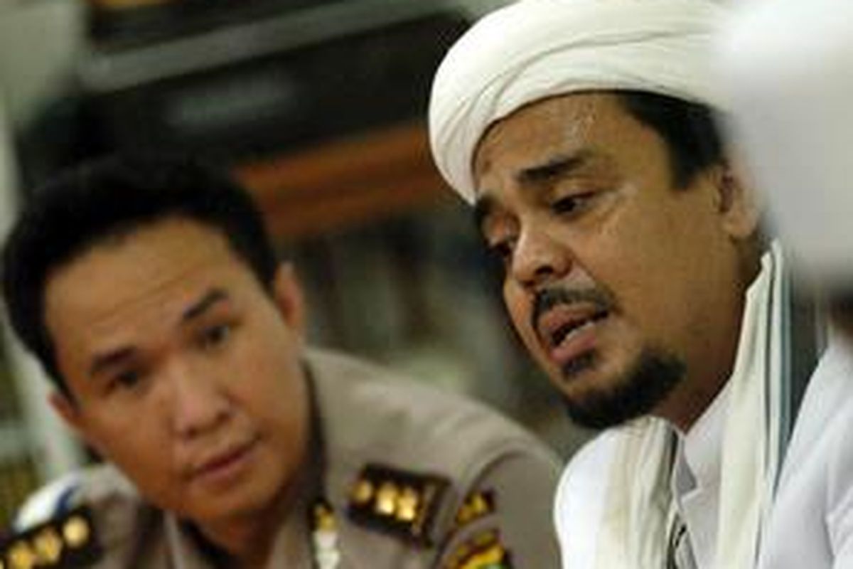 Ketua Front Pembela Islam (FPI), Habib Rizieq Shihab (kanan) berbicara dengan anggota kepolisian di Markas FPI, Petamburan, Jakarta Pusat, Rabu (4/6).