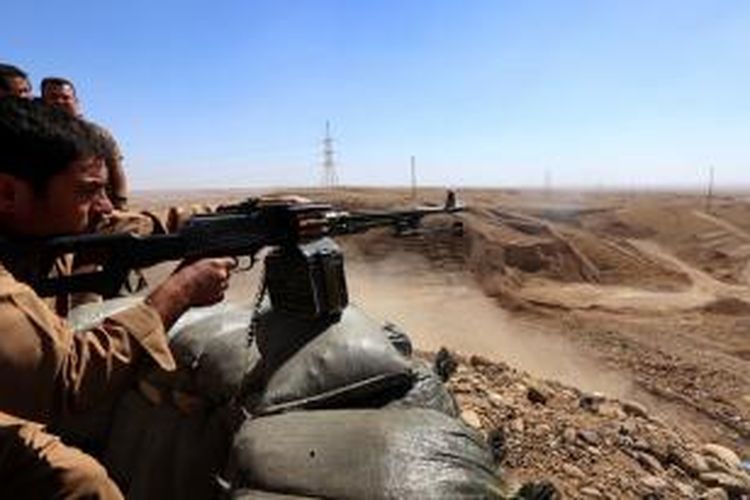 Seorang prajurit Peshmerga Kurdi mengarahkan senapan mesinnya ke arah pasukan ISIS di wilayah Jalawla, provinsi Diyala, Irak.