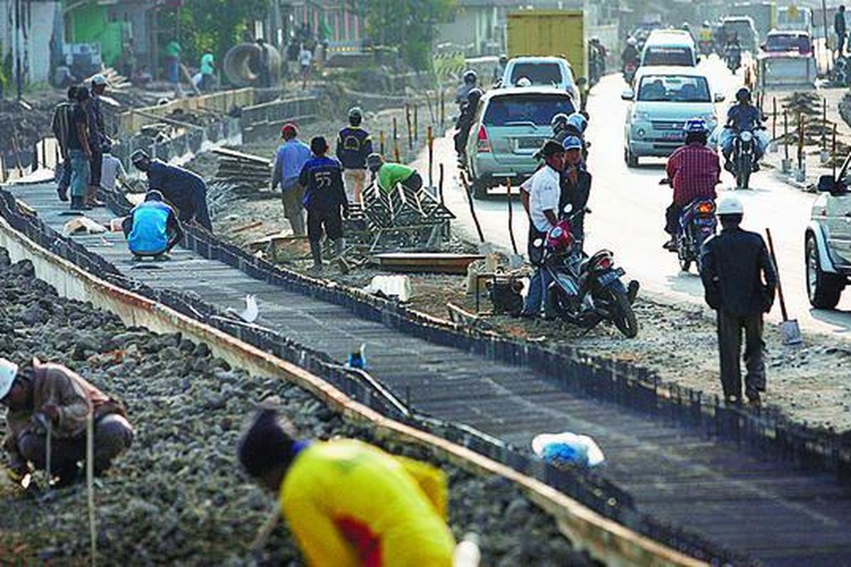 Iulstrasi: Pekerja menyelesaikan proyek pelebaran jalan.