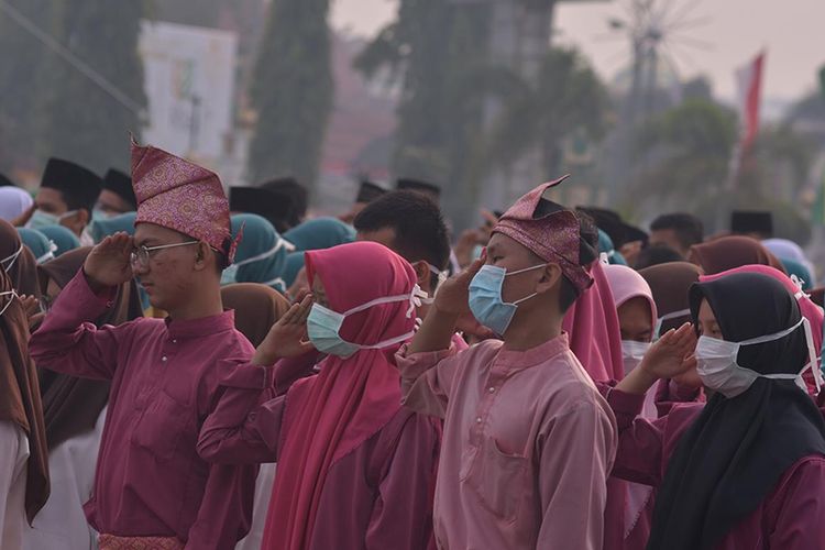 Peserta upacara HUT ke-62 Riau mengenakan masker, karena kabut asap karhutla cukup pekat menyelimuti wilayah Kota Pekanbaru, Riau, Jumat (9/8/2019).