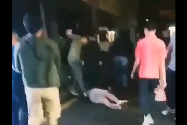Tangkapan layar seorang suporter Indonesia sedang dipukuli.