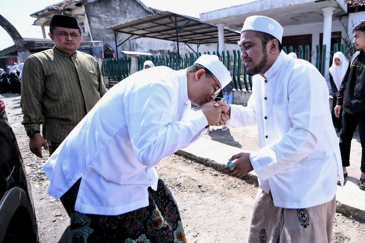 Bakal calon presiden dari Koalisi Perubahan dan Persatuan (KPP) Anies Baswedan mencium tangan Gus Hasan Jazuli yang merupakan pimpinan Pesantren Raiyatul Husnan di Bondowoso, Jawa Timur, Rabu (9/8/2023).