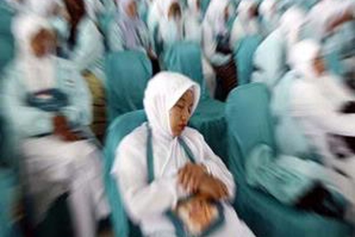 Seorang calon haji asal Banjarmasin tertidur menunggu giliran regestrasi akhir sebelum pemberangkatan di aula Embarkasi Haji Banjarmasin, Kalsel, Selasa (4/11).