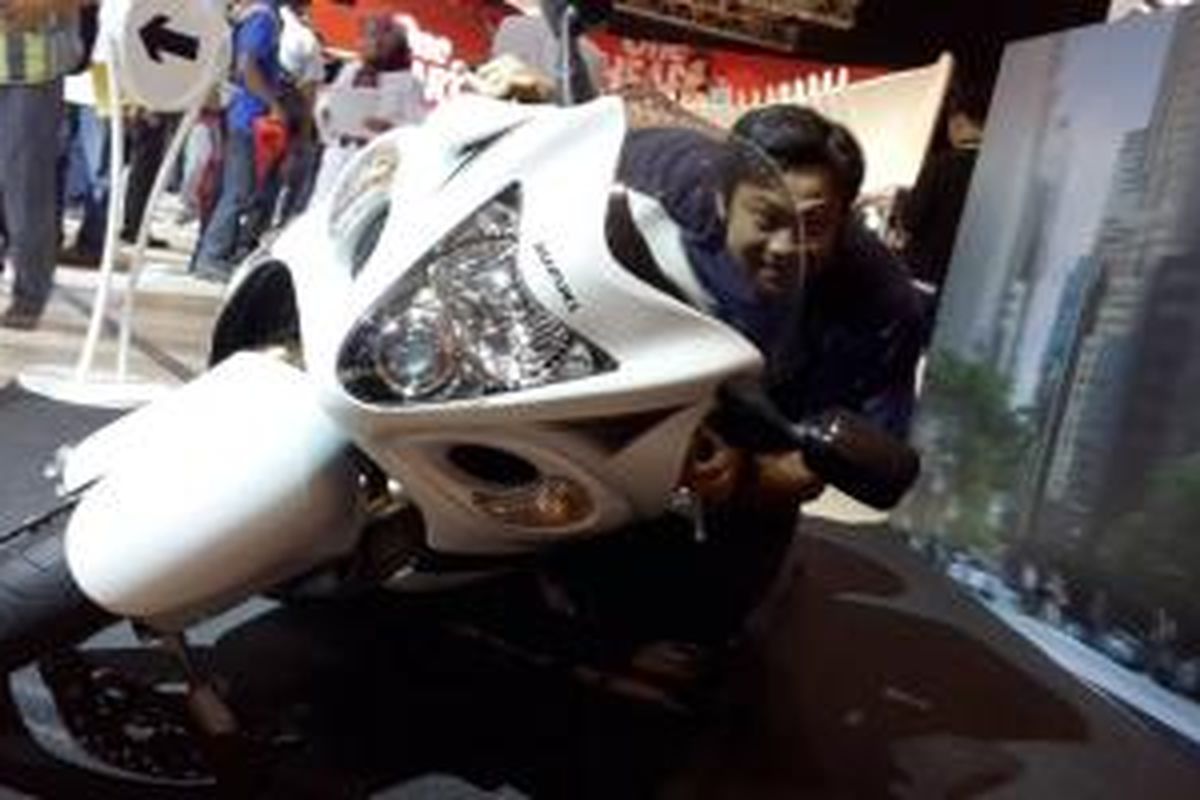 Pengunjung sedang menaiki Suzuki Hayabusa yang diletakkan miring untuk objek foto di stan Suzuki IMoS 2014.